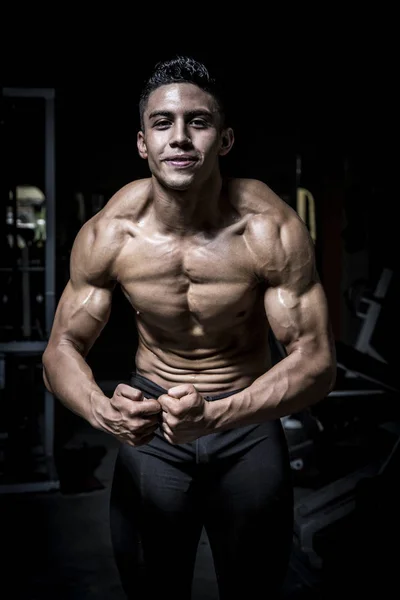 Young man exercising in dark and old gym