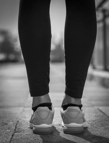 Runner feet running on road closeup on shoe. Woman fitness.