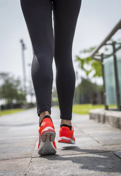 Runner feet running on road closeup on shoe. Woman fitness.