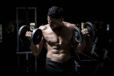 Genç adam karanlık ve yaşlı spor salonunda egzersiz yapıyor.