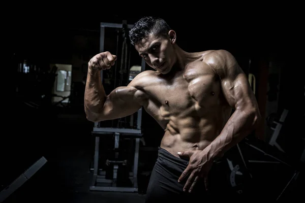 Young man exercising in dark and old gym