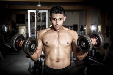 Genç adam karanlık ve yaşlı spor salonunda egzersiz yapıyor.