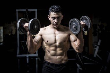 Genç adam karanlık ve yaşlı spor salonunda egzersiz yapıyor.