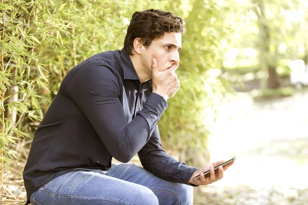 Young Troubled Businessman Sitting Garden Cell Phone His Hand — Stock Photo, Image