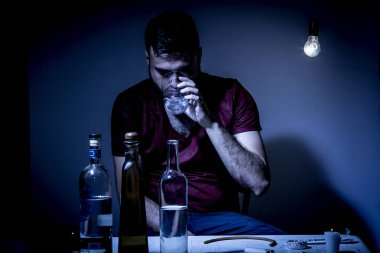 Sakallı genç adam, alkolizm, sigara ve uyuşturucu bağımlılığında kaybolmuş.