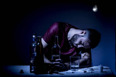 Sakallı genç adam, alkolizm, sigara ve uyuşturucu bağımlılığında kaybolmuş.