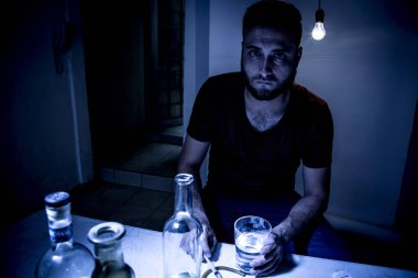 Sakallı genç adam, alkolizm, sigara ve uyuşturucu bağımlılığında kaybolmuş.