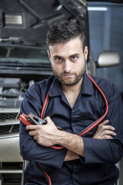 Garajdaki tamirci motoru tamir ediyor.