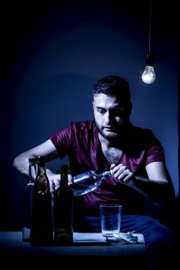 Sakallı genç adam, alkolizm, sigara ve uyuşturucu bağımlılığında kaybolmuş.