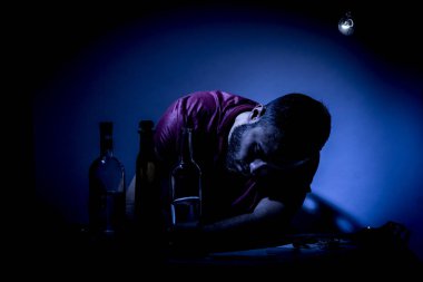 Sakallı genç adam, alkolizm, sigara ve uyuşturucu bağımlılığında kaybolmuş.