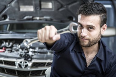 Garajdaki tamirci motoru tamir ediyor.