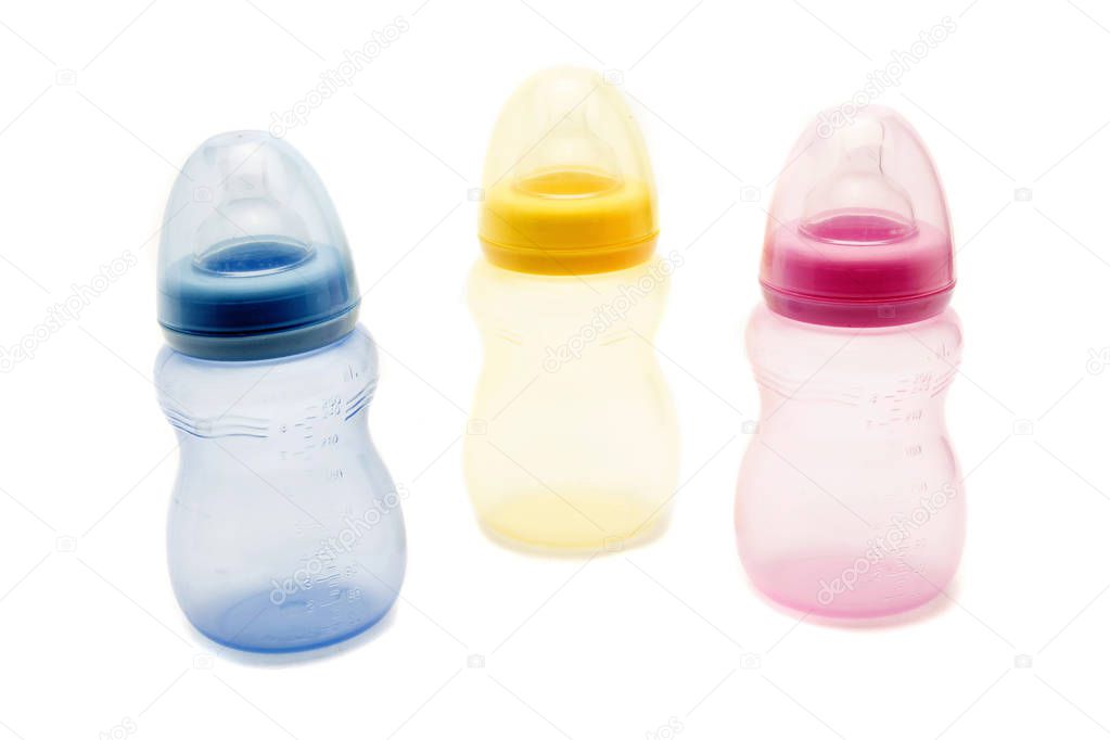 Colorful baby bottles on white background