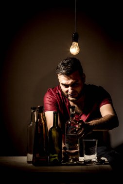 Sakallı genç adam, alkolizm, sigara ve uyuşturucu bağımlılığında kaybolmuş.