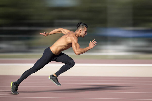 Sprinter leaving  on the running track. Explosive start.