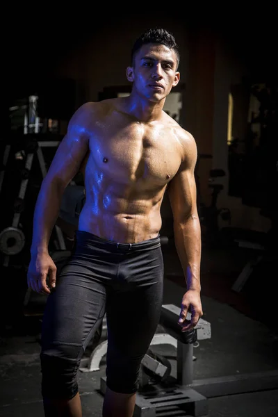 Молодой Мускулистый Человек Спортзале Делает Упражнения Показывать Свои Мускулы — стоковое фото