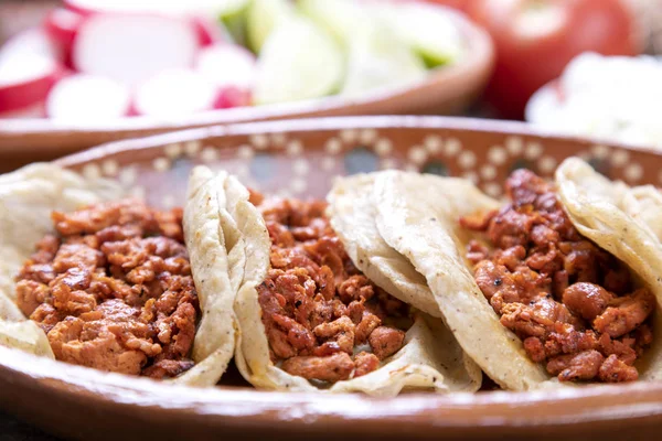 肉卷到牧羊人或腌制 典型的墨西哥食物在一个质朴的餐桌上 满是调味汁和蔬菜 — 图库照片