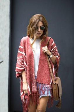 Sokakta yürürken moda giysiler giyen güzel genç kadın