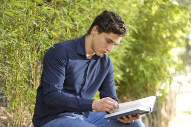 Genç işadamı açık bahçe Kutsal İncil okuma