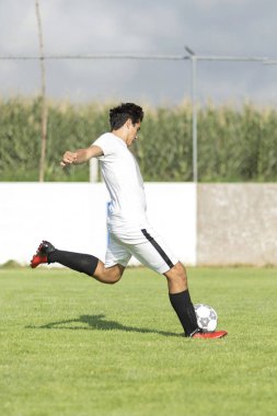 Çim sahası içinde topu çekim genç futbolcu