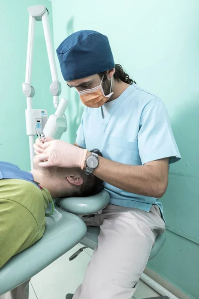 A young male dentist and a patient. Dentist office lifestyle scene. Doctor practice. Patient health care