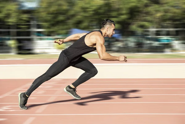 Sprinter leaving starting blocks on the running track. Explosive start.