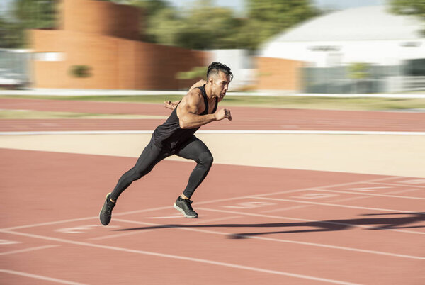 Sprinter leaving starting blocks on the running track. Explosive start.