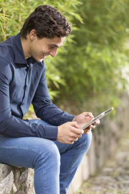 Kamera ve manifatura doğru telefon üzerinde yürüme gülümseyen genç bir işadamı portresi önden görünüm