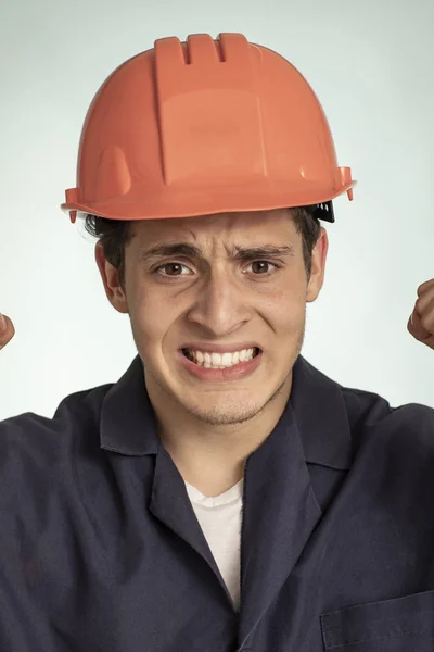 Real frustrated mechanic man detail with safety helmet on his head
