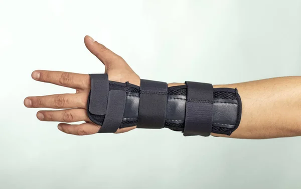 Man hand with adjustable immobilizer for injuries of bones and muscles.. Orthopedic device.human, dark,