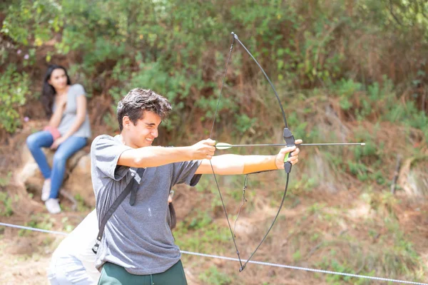 Chico con arco lanzando su flecha al blanco — Foto de Stock