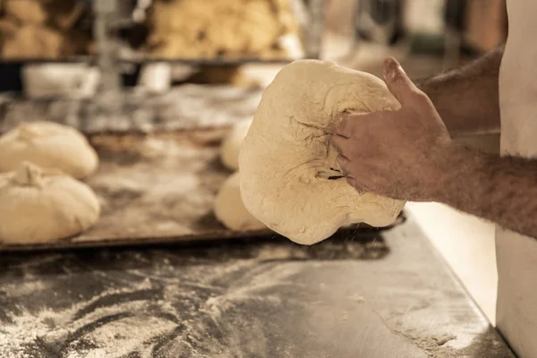 Hands of the master baker in bread production — Stock Photo, Image