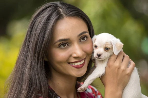 Woman with a small white puppy in her hands. — Stock Photo, Image