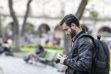 Sakallı fotoğrafçı ve fotoğraf makinesi açık havada.