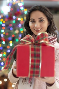 Arka planda hediye ve noel ağacı ile kadın