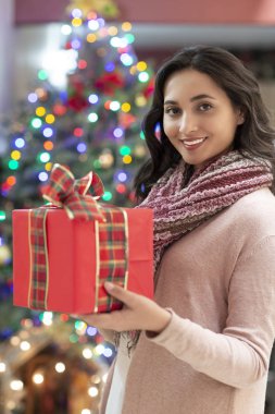 Arka planda hediye ve noel ağacı ile kadın