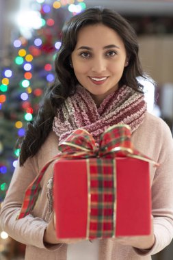 Arka planda hediye ve noel ağacı ile kadın