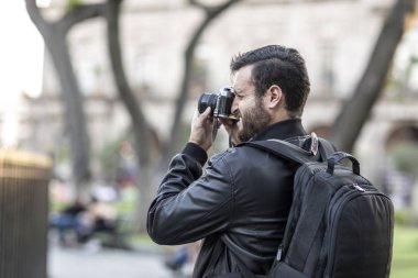 Sakallı fotoğrafçı ve fotoğraf makinesi açık havada.