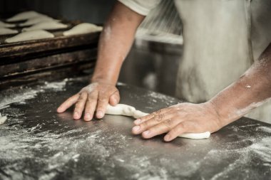 öğretmen baker masada ekmek üretiminde elinde