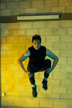 Genç ve çekici bir adam bodrumda break dans yapıyor.