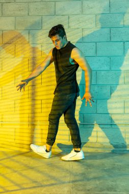 Genç ve çekici bir adam bodrumda break dans yapıyor.