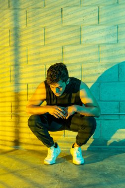 Genç ve çekici bir adam bodrumda break dans yapıyor.