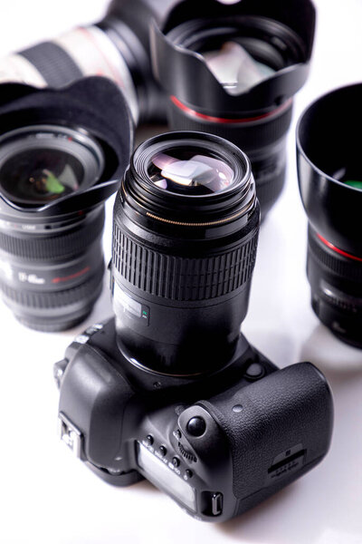 professional photographic equipment with digital camera, lenses and accessories. Dark atmosphere
