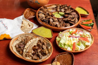 Lezzetli ızgara biftek ve koyun, yanında da tortilla sosu ve salata. Meksika yemeği.