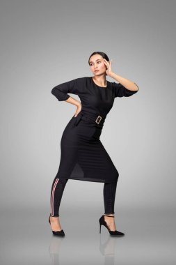 Stüdyoda siyah giysiler içinde poz veren güzel esmer manken..
