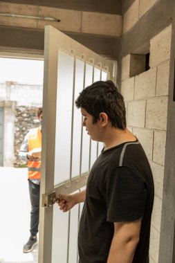 Yakışıklı ve zarif bir adam eve yemek getiriyor. COVID-19 salgını sırasında ağız kapağı kullanıyor.