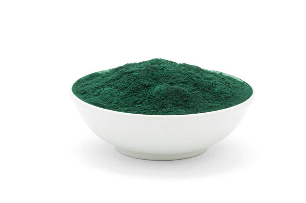 Фарфоровая чаша с зеленым порошком на белом фоне.