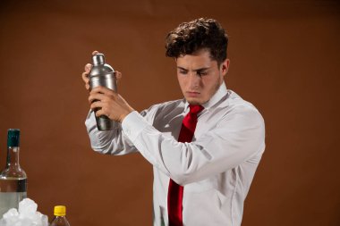 Barmen barda alkollü bir içecek hazırlıyor. Yanında da bir bardak likör.. 