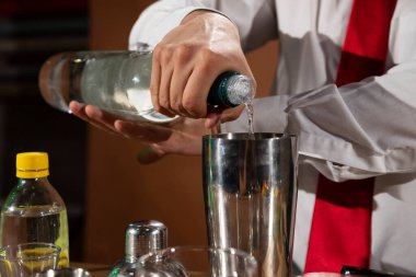 Barmen barda alkollü bir içecek hazırlıyor. Yanında da bir bardak likör.. 