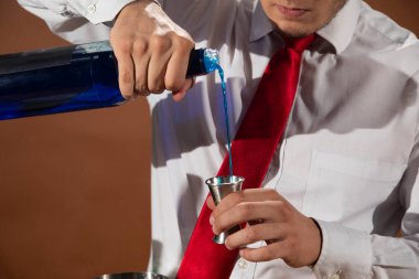 Barmen barda alkollü bir içecek hazırlıyor. Yanında da bir bardak likör.. 