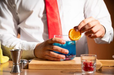 Barmen barda alkollü bir içecek hazırlıyor. Yanında da bir bardak likör.. 